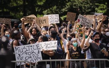 A crowd holding Black Lives Matter signs during a protest. image link to story