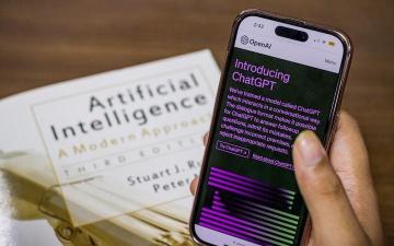 person holding a phone with ChatGPT on its screen image link to story