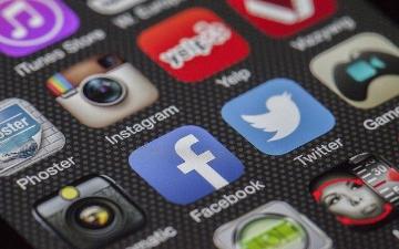 Smartphone screen displaying various social media app icons, including Facebook, Twitter, and Instagram. image link to story