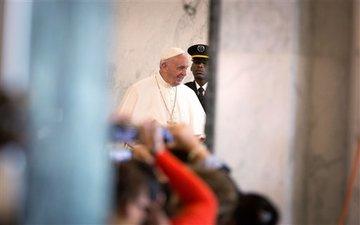 Pope Francis greeting people in a corridor. image link to story