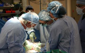Doctors in operating room performing surgery. image link to story