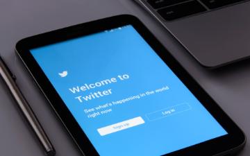 Tablet displaying Twitter login screen next to a laptop and pen. image link to story