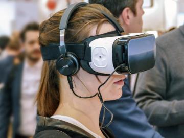 A woman wears a Virtual Reality headset.