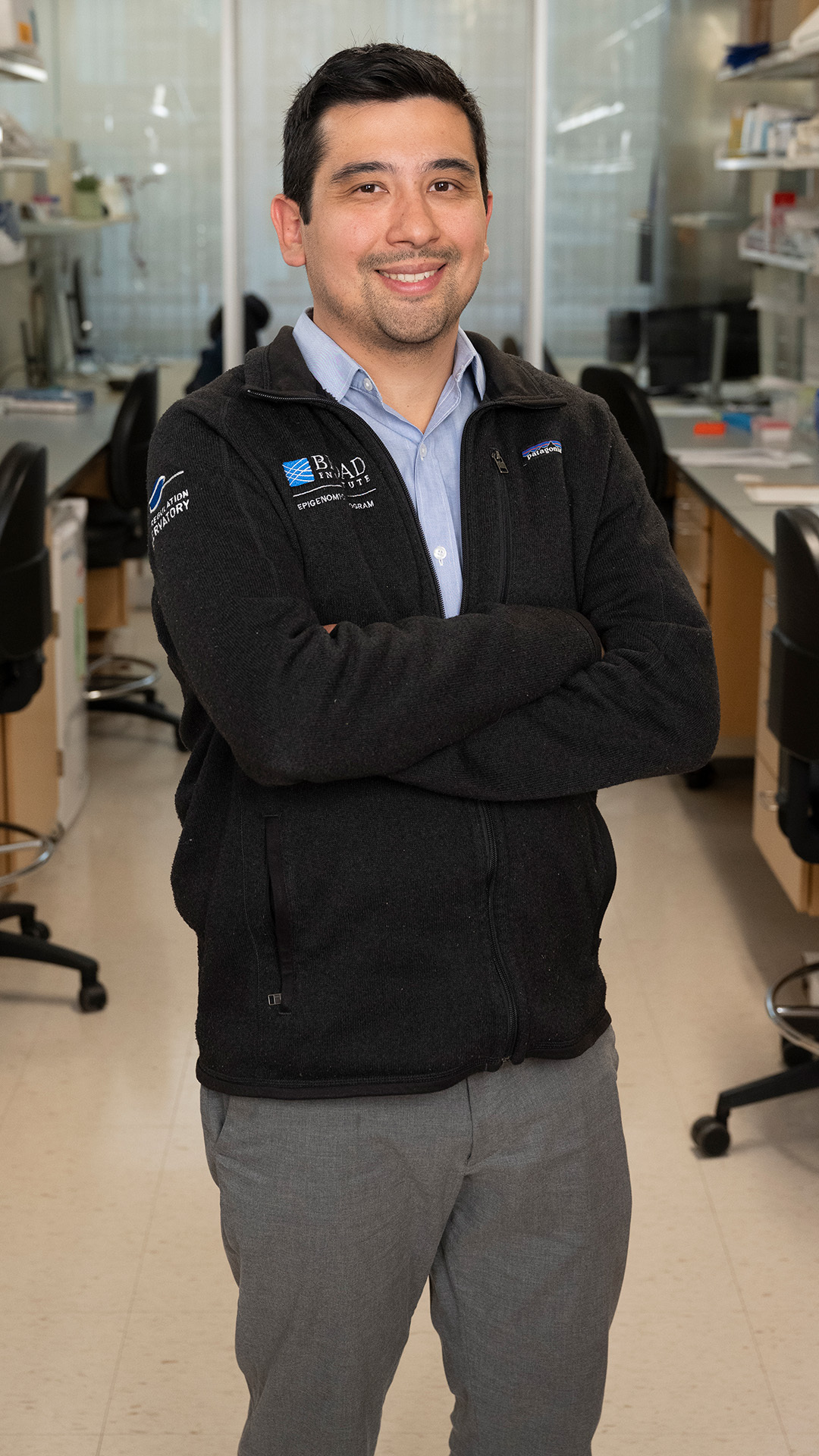 Jason Buenrostro ’09 posing with their arms crossed in a laboratory setting
