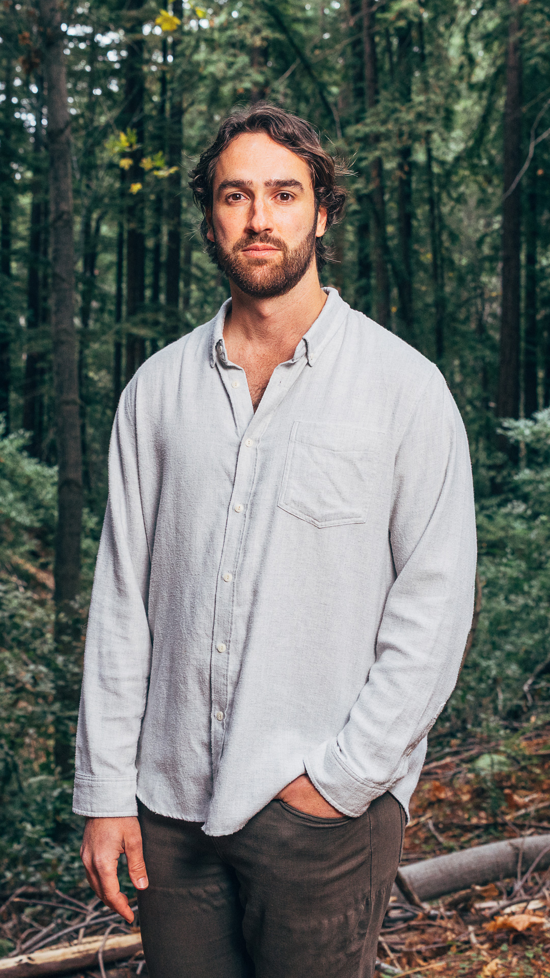 Sean Reilly stands facing forward with his left hand in his pants pocket