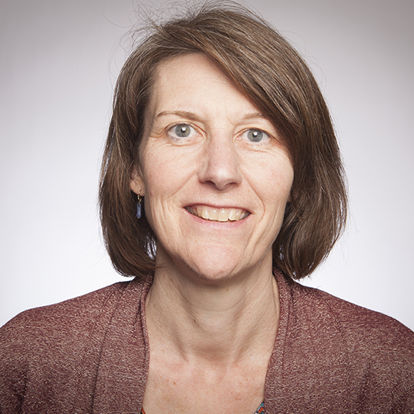 A person smiling, wearing a maroon top.