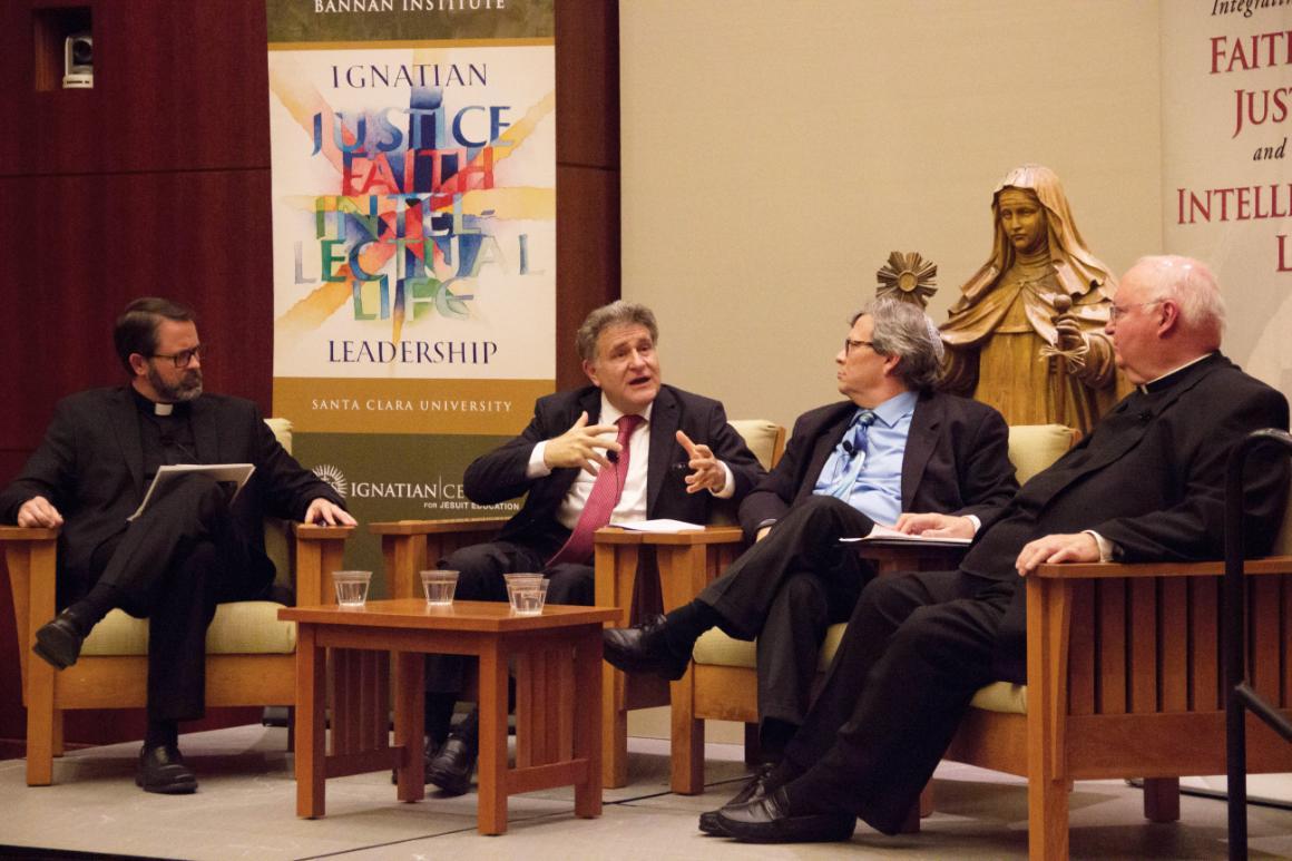 Four individuals seated discussing on stage near a 'Skorka' banner.