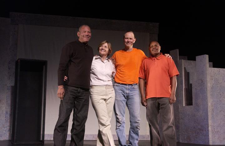 Four people standing together on stage for 