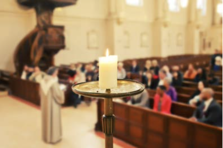 Candle lit in front of church