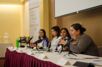 Four people sitting at a panel table with microphones.