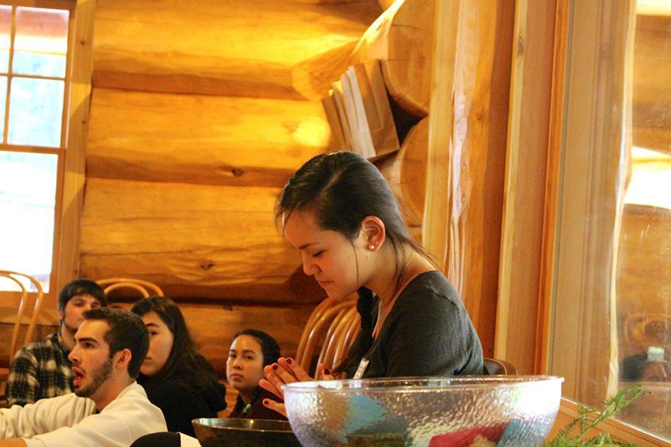 People gathered indoors, engaging in conversation at a Campus Ministry retreat.