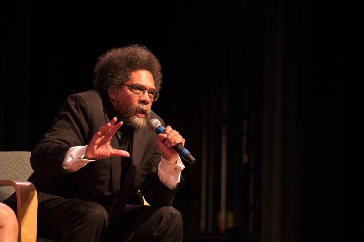Cornel West speaking into a microphone on stage.