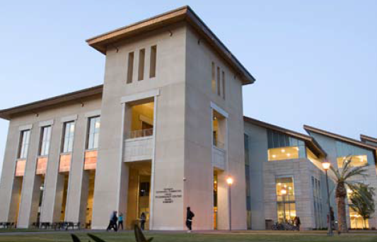 A modern building with large windows at dusk.