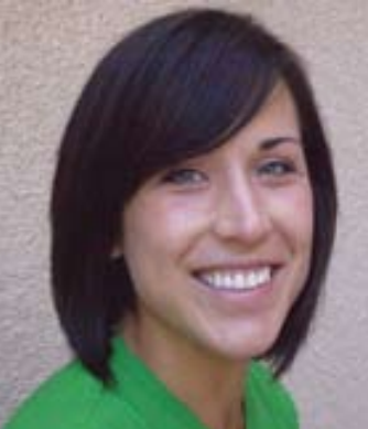 A person smiling against a neutral background.