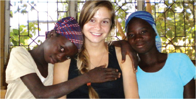 Three people smiling and posing together outside in casual clothing.