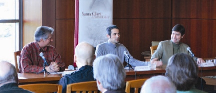 Three people sitting and conversing in a warmly lit room.