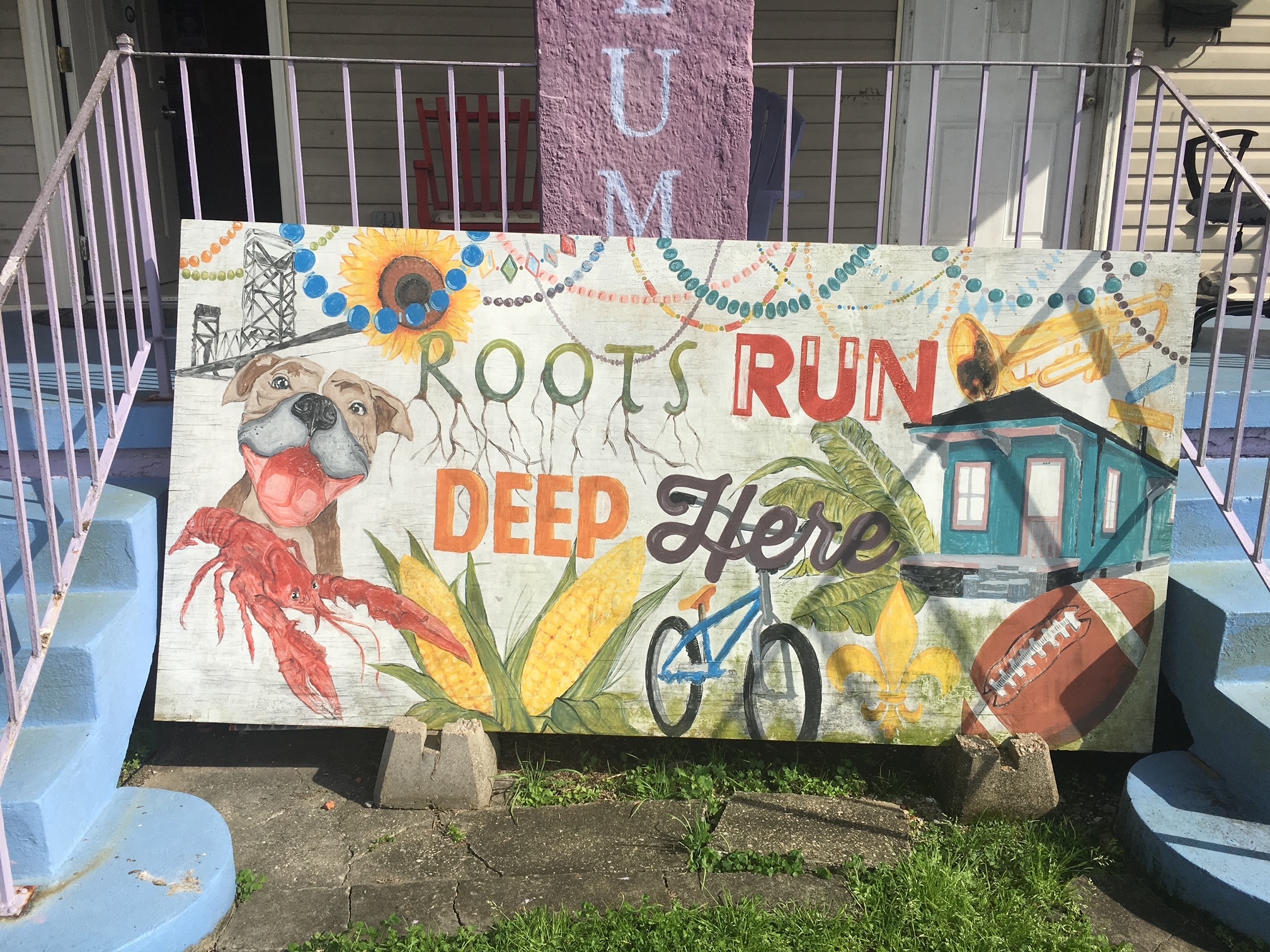 A hand-painted New Orleans sign with colorful graffiti text and designs.