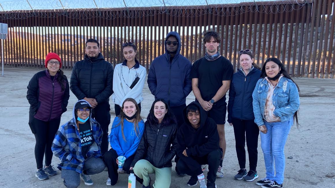 A group named San Diego Immersion Group posing in front of a wall.