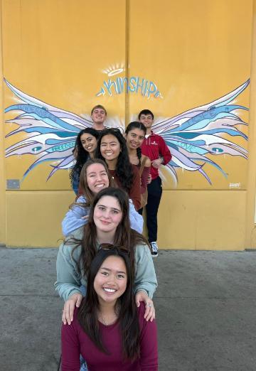 LA Immersion group with Kinship Wings mural in background