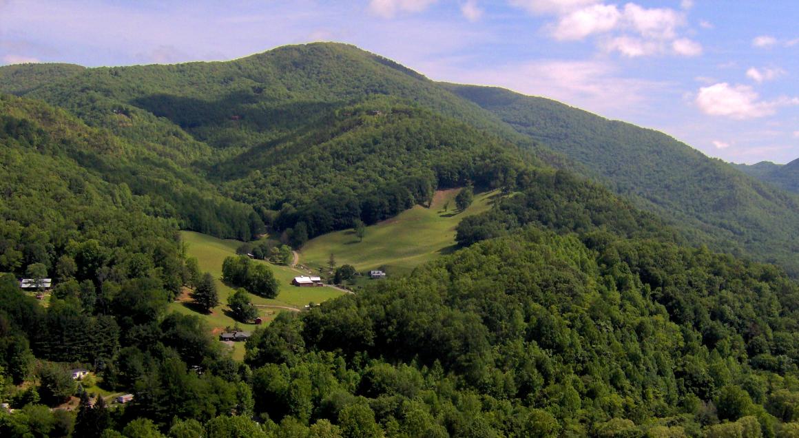 Panoramic view of lush, green Appalachian mountains under a partly cloudy sky.