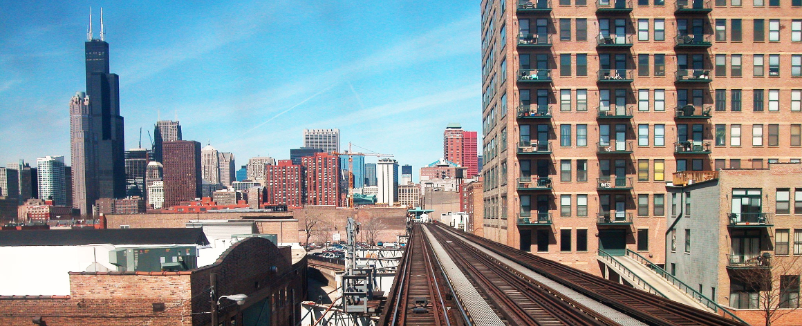 Chicago cityscape with elevated railway tracks and tall buildings.
