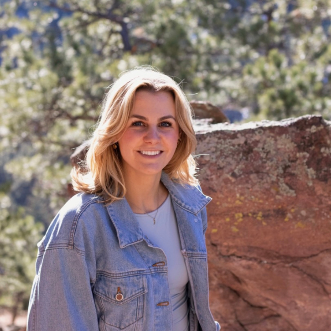 A student in front of trees and rocks