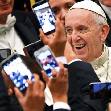 Pope Francis surrounded by cell phones