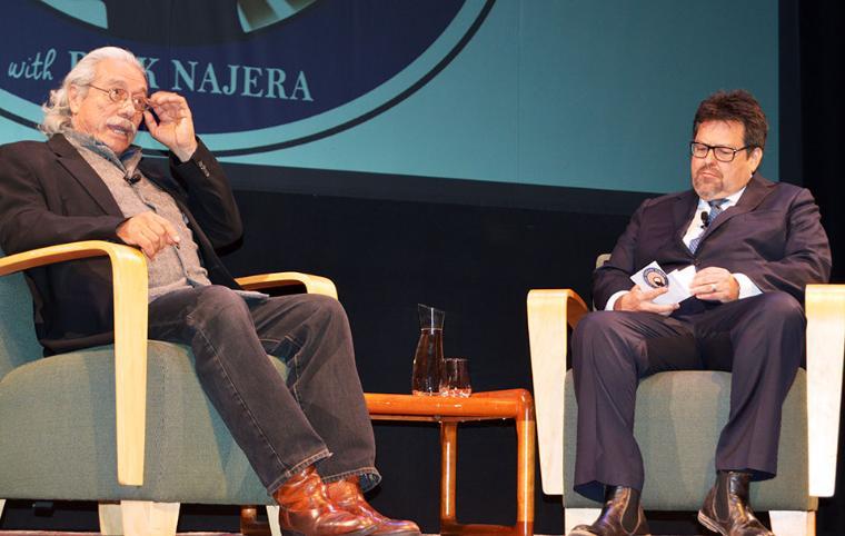 Two men seated on stage at Latino Summit conference.