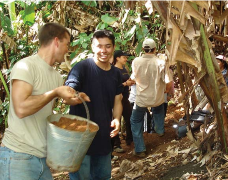 People carrying buckets in a forest setting, engaging in presumably water-related activities.
