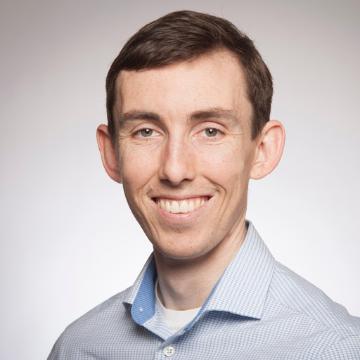 A person smiling in a professional headshot.