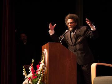 A person speaking at a podium on stage.