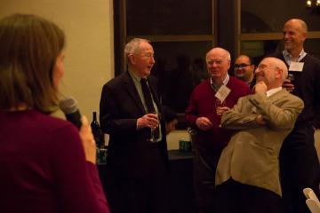 A person addressing a group of people in a gallery setting.