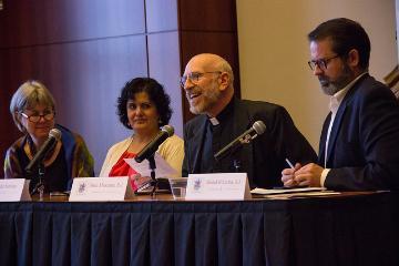 Four people speaking on a panel at a conference.