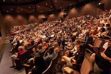 A large audience seated in an auditorium.