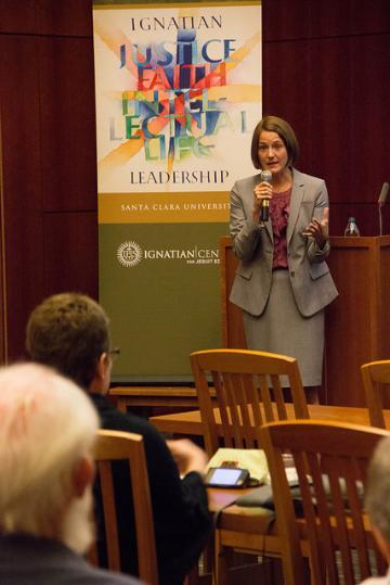 A person speaks at a podium in front of an audience.