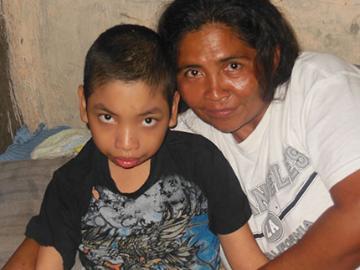 A child and an adult smiling together.