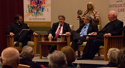 Panel discussion with four people seated on a stage in front of an audience.