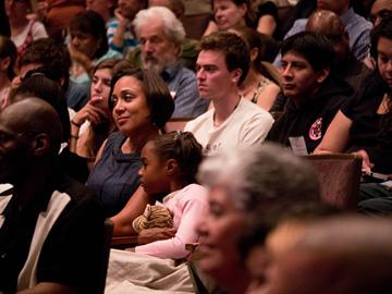 A group of people attentively watching an event.