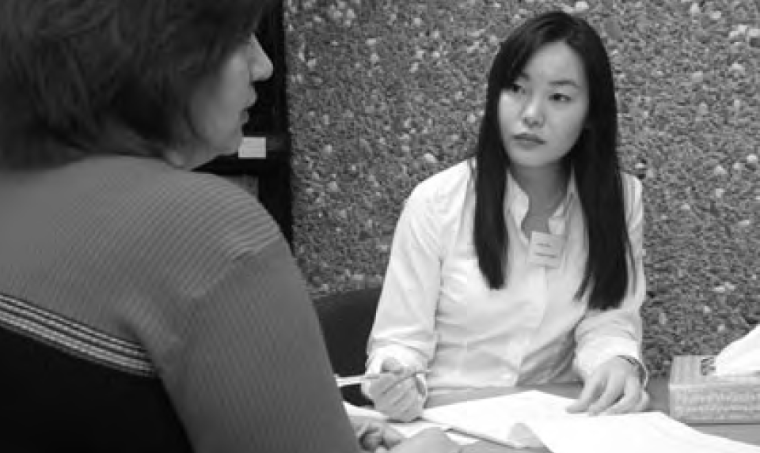 Two women discussing papers at a table.