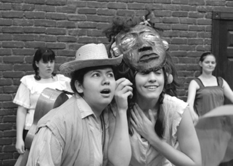 Two performers in a play, one wearing an animal mask.