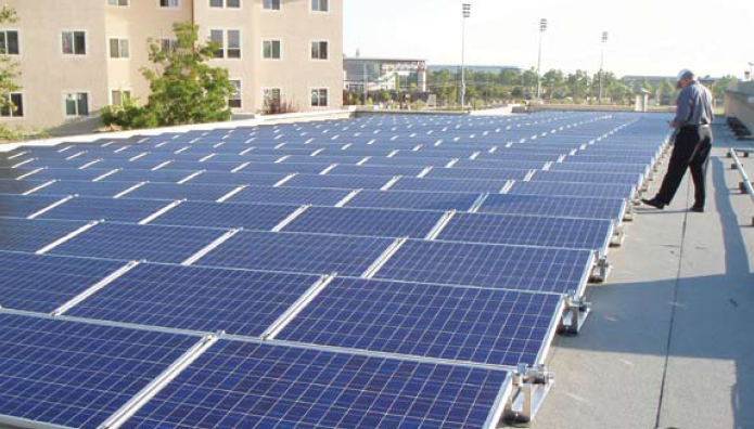Person standing near solar panels on a rooftop.
