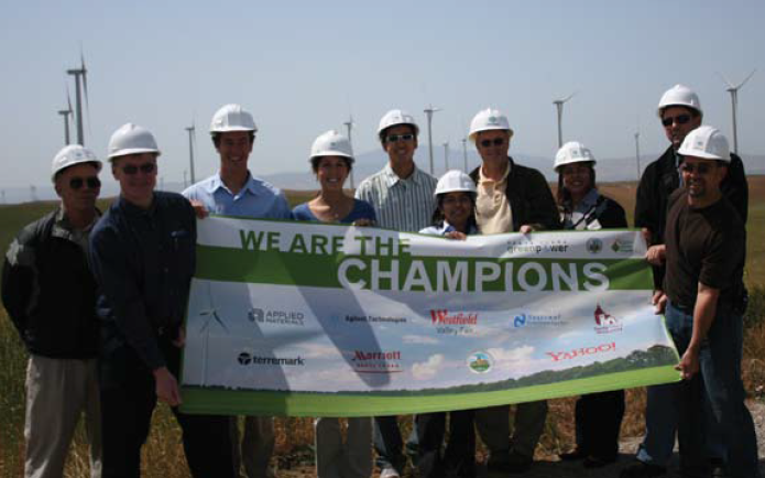 Group of people holding a banner promoting sustainability on campus, all wearing helmets.