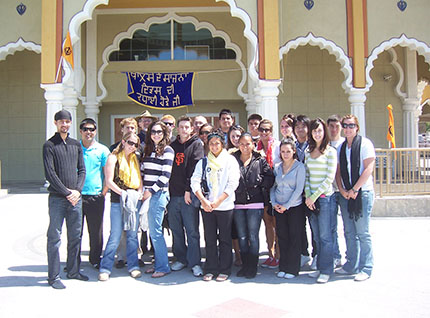 A group of students posing in front of an ornate building.