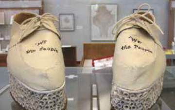 Handmade shoes displayed with text: This Way Up written on the soles.
