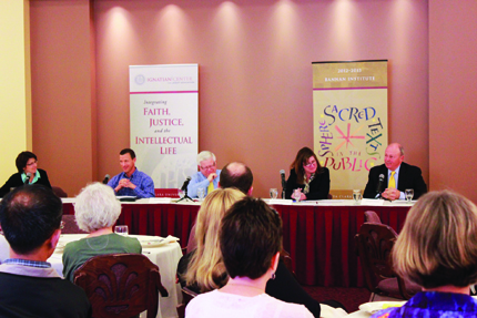 Panel discussion with five people seated at a table, audience in foreground.
