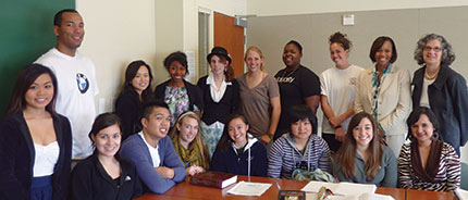A group of people posing together in a classroom.