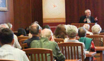 A speaker addressing an audience in a lecture hall.