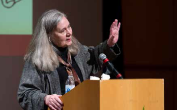 A person speaking at a podium with a microphone.