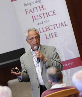 A person speaking in front of a banner with text.