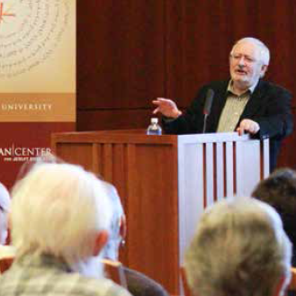 A person speaking at a podium in front of an audience.